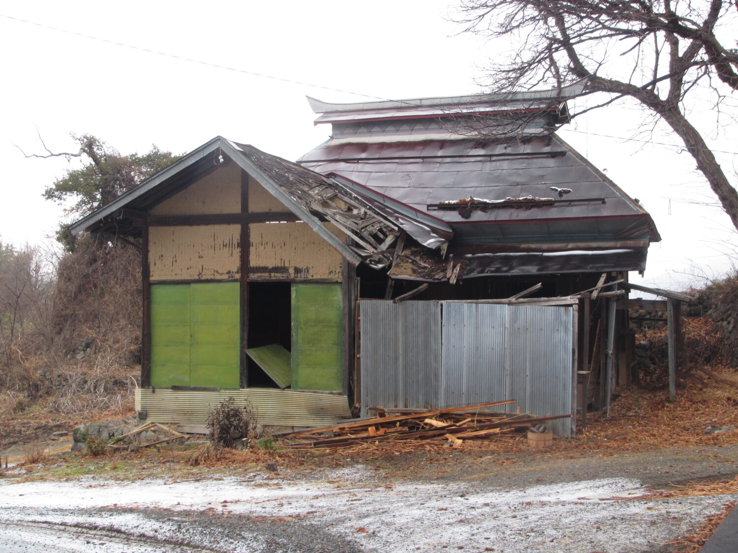 解体する茅葺小屋